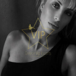 Black-and-white portrait of a woman in a black top with a gold VIP star watermark reading 'Greece Vip Escorts'.