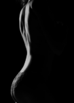 Side silhouette of a person in lace underwear against a black background, with dramatic lighting.