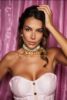 Portrait of a woman with dark hair, wearing a pink strapless top and pearl necklace, posing against a pink satin backdrop; watermark reads 'Paris Athens Escorts'. Portrait of a woman with dark hair, wearing a pink strapless top and pearl necklace, posing against a pink satin backdrop; watermark reads 'Paris Athens Escorts'.