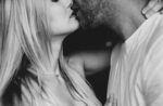 Close-up of a couple kissing, faces and necks in frame in a tender, intimate moment (black-and-white).